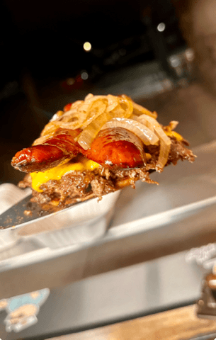 Smashed beef patty topped with melted cheese, split grilled sausages, and caramelized onions.